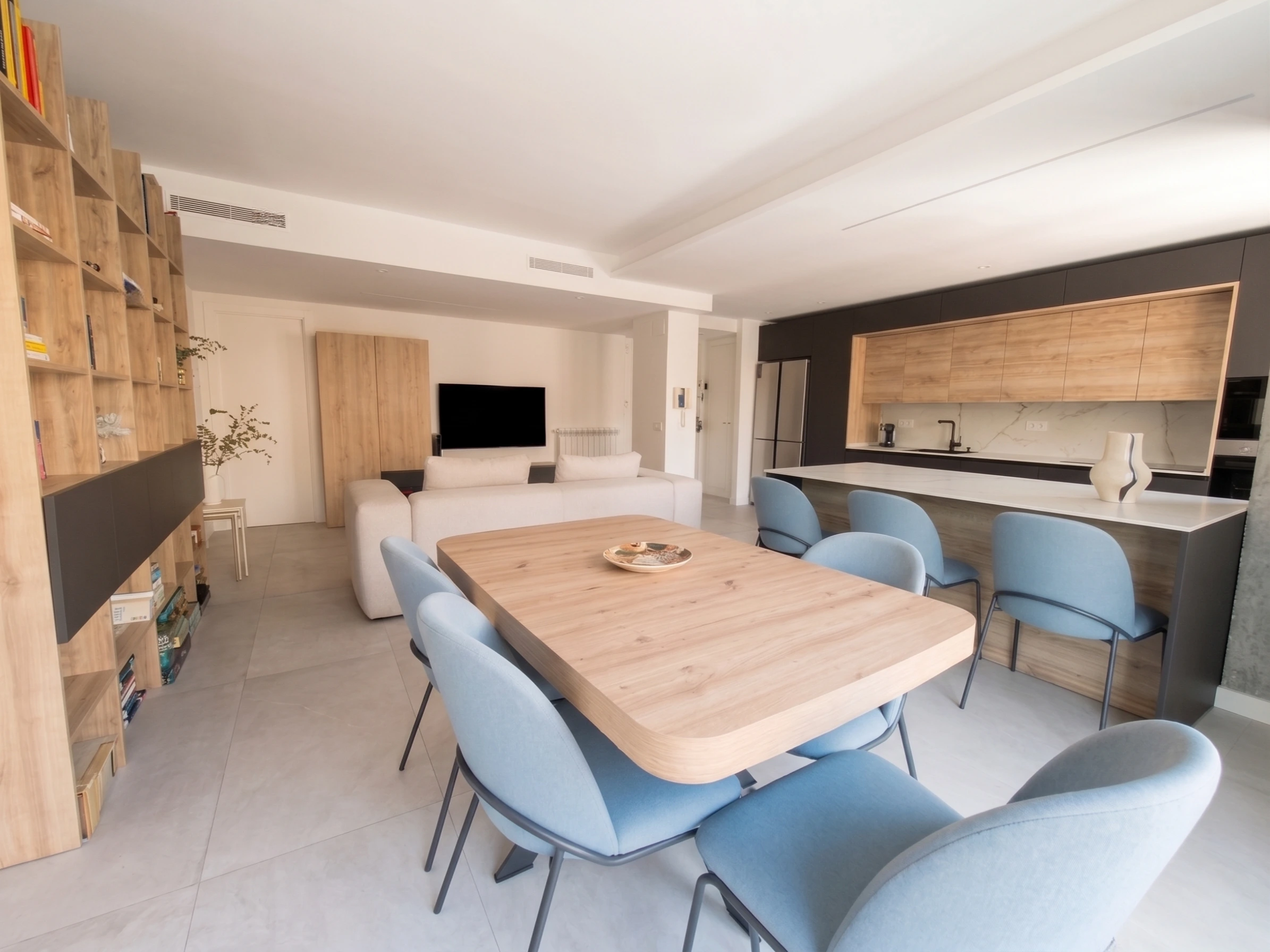 Reforma integral de vivienda con diseño de concepto abierto que une cocina, salón y comedor moderno en Madrid.